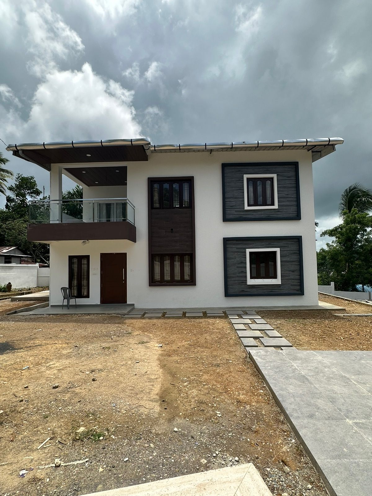 A completed two-storey residence built by Telamon Engineering Solution, with a balcony, textured cladding and a paved approach
